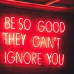 Red glowing sign that says 'be so good they can't ignore you.'