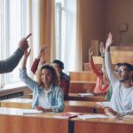 students raising hands in class